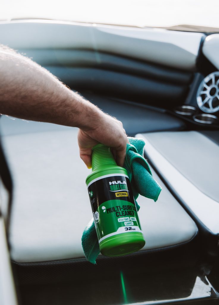 Hula Boat Care interior multi-surface cleaner spray bottle with microfiber cloth on boat console